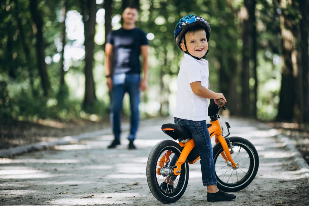 pai ensinando filho a andar de bicicleta